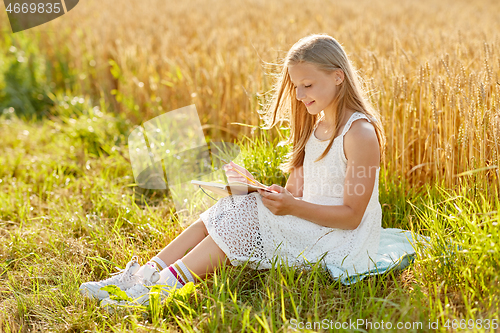 Image of smiling girl writing to diary on cereal field