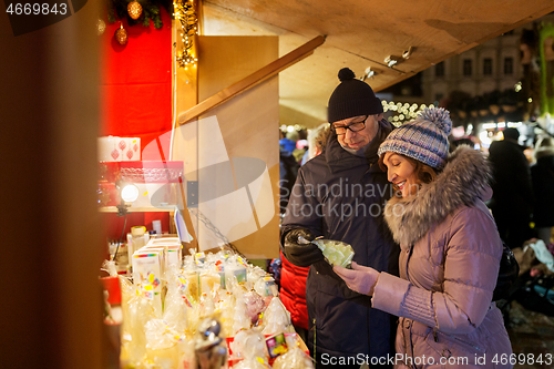 Image of happy senior couple hugging at christmas market