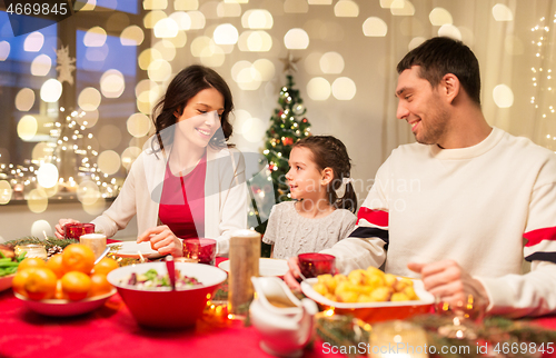 Image of happy family having christmas dinner at home