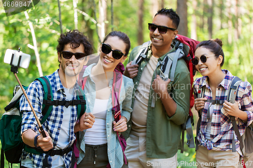 Image of friends with backpacks hiking and taking selfie