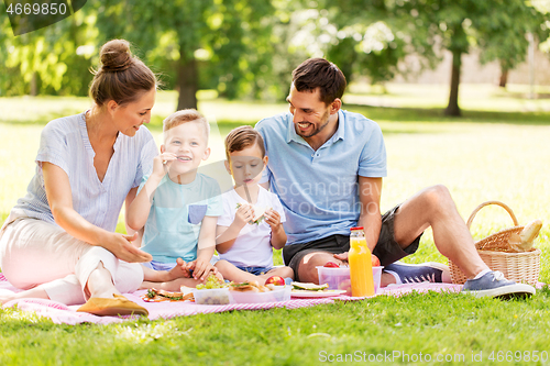 Image of happy family having picnic at summer park