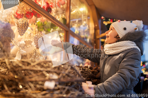 Image of girl choosing christmas decorations at market