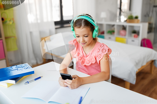 Image of girl in headphones listening to music on cellphone