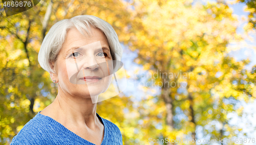 Image of portrait of senior woman in autumn park