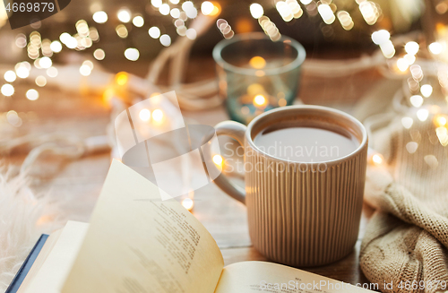 Image of book and cup of coffee or hot chocolate on table