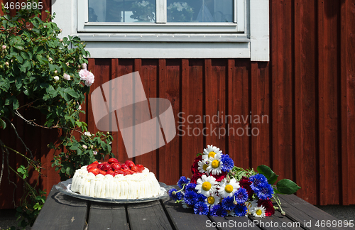 Image of Decorated summer table in front of a red house