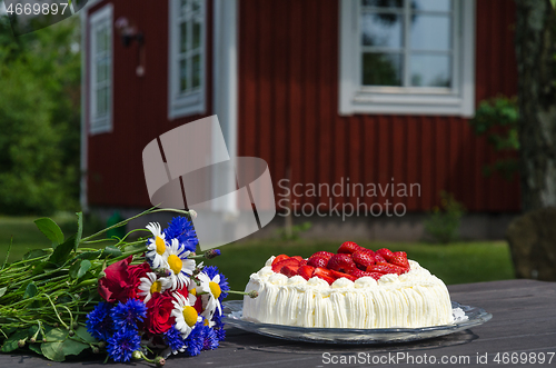 Image of Flowers and strawberry cake on a table
