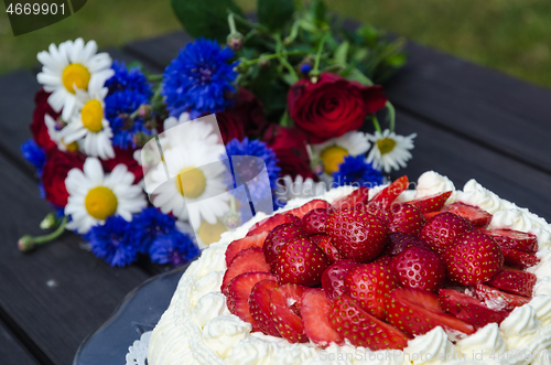 Image of Strawberry cream cake with summer flowers