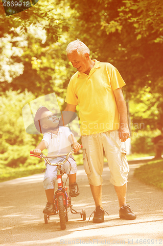 Image of grandfather and child have fun  in park