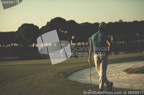 Image of golfer from back at course looking to hole in distance