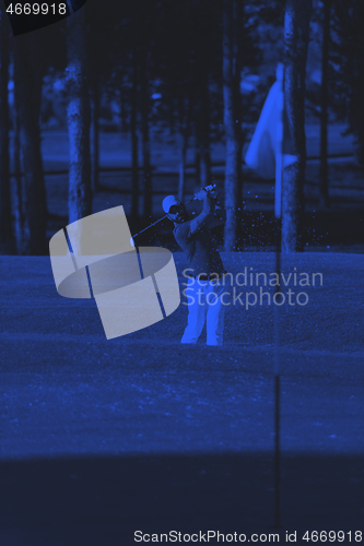 Image of pro golfer hitting a sand bunker shot