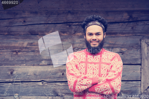 Image of portrait of young hipster in front of wooden house