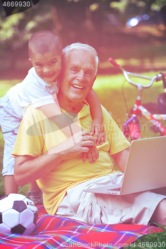 Image of grandfather and child using laptop