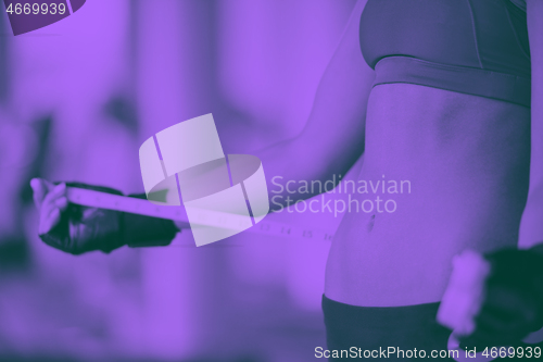 Image of young fit woman measuring belly