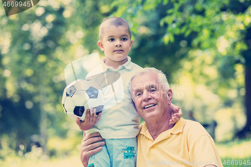 Image of grandfather and child have fun  in park