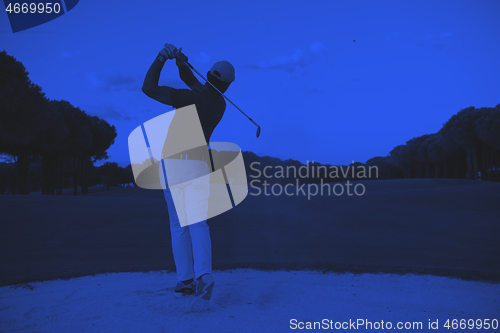 Image of golfer hitting a sand bunker shot on sunset