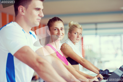 Image of friends  exercising on a treadmill at the bright modern gym