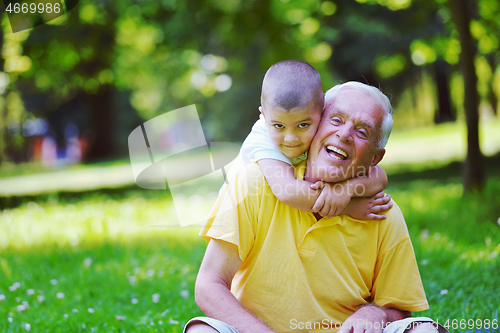 Image of happy grandfather and child in park