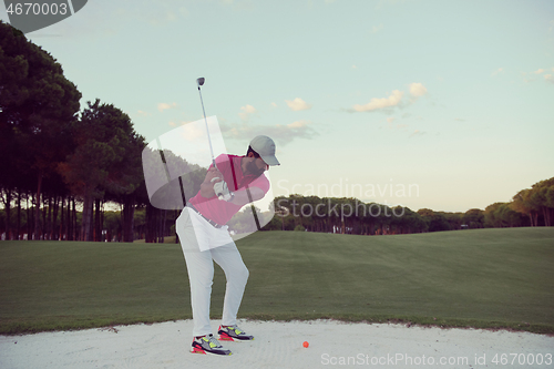 Image of golfer hitting a sand bunker shot on sunset