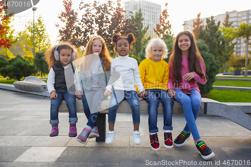 Image of Interracial group of kids, girls and boys playing together at the park in summer day