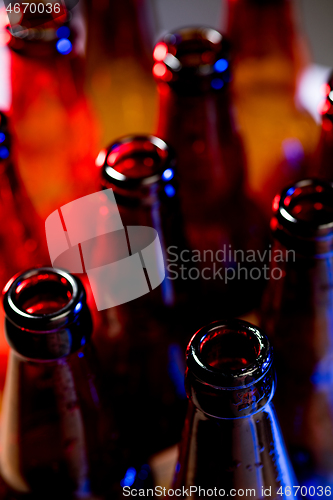 Image of Neon colored beer bottles. Close up on bright studio background