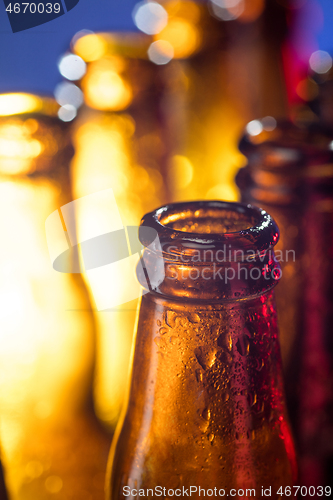 Image of Neon colored beer bottles. Close up on bright studio background