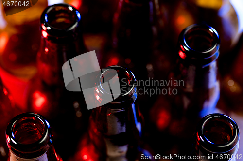 Image of Neon colored beer bottles. Close up on bright studio background