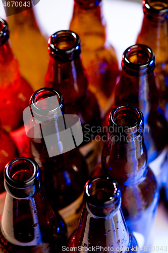 Image of Neon colored beer bottles. Close up on bright studio background