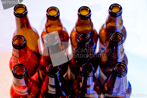 Image of Neon colored beer bottles. Close up on bright studio background