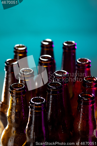 Image of Neon colored beer bottles. Close up on bright studio background