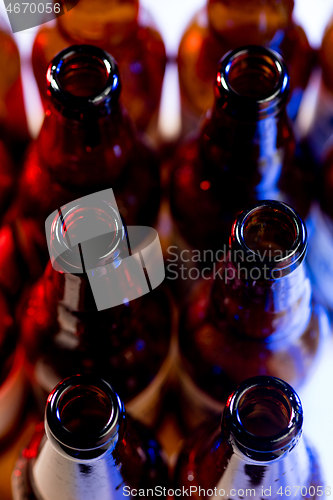 Image of Neon colored beer bottles. Close up on bright studio background