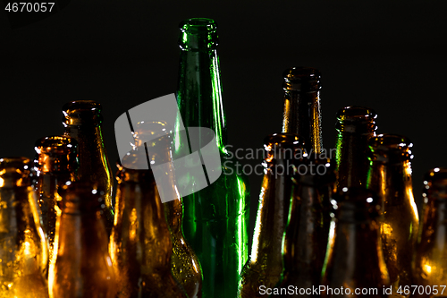 Image of Neon colored beer bottles. Close up on bright studio background