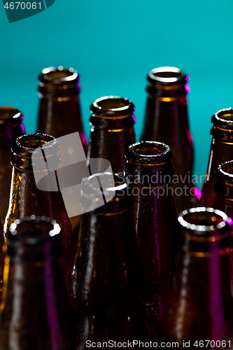 Image of Neon colored beer bottles. Close up on bright studio background