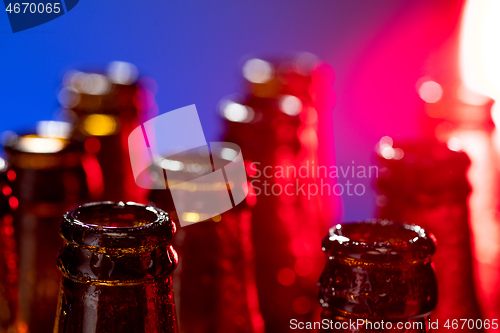 Image of Neon colored beer bottles. Close up on bright studio background