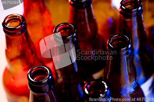 Image of Neon colored beer bottles. Close up on bright studio background