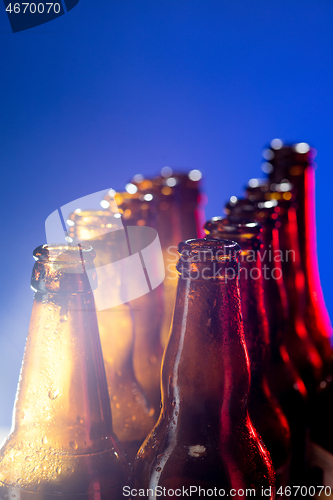 Image of Neon colored beer bottles. Close up on bright studio background