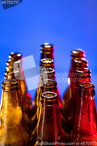 Image of Neon colored beer bottles. Close up on bright studio background