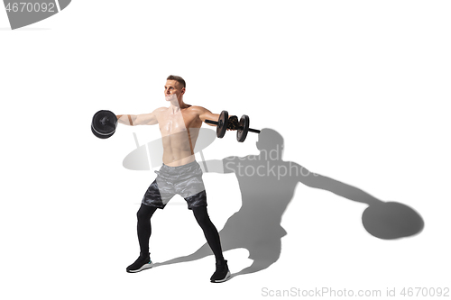 Image of Beautiful young male athlete practicing on white studio background with shadows