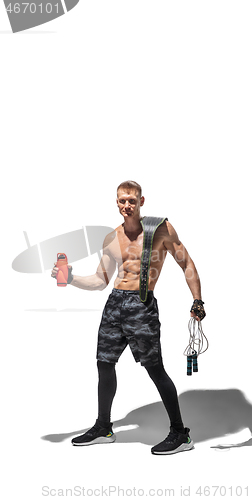 Image of Beautiful young male athlete practicing on white studio background with shadows