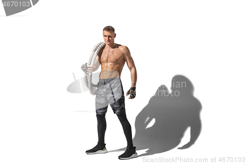 Image of Beautiful young male athlete practicing on white studio background with shadows