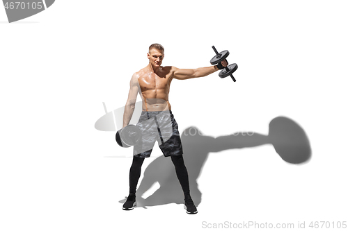 Image of Beautiful young male athlete practicing on white studio background with shadows