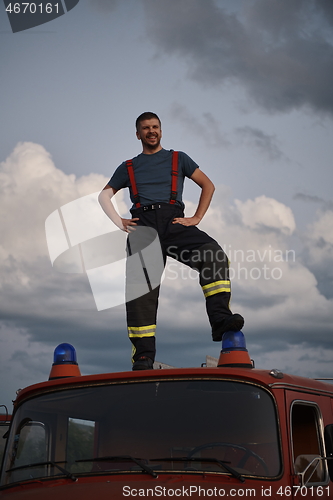 Image of firefighter out of duty on top of truck