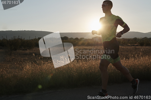 Image of triathlon athlete running on morning trainig