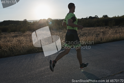 Image of triathlon athlete running on morning trainig