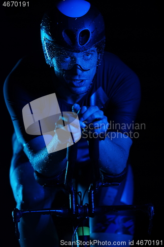 Image of triathlon athlete riding bike fast at night