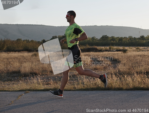 Image of triathlon athlete running on morning trainig