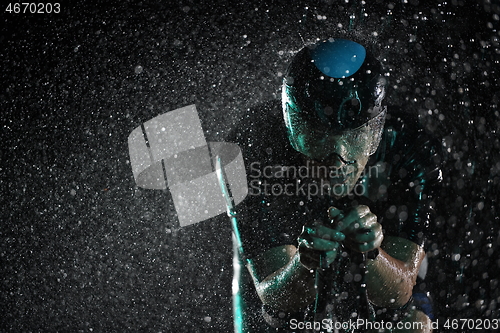 Image of triathlon athlete riding bike fast on rainy night