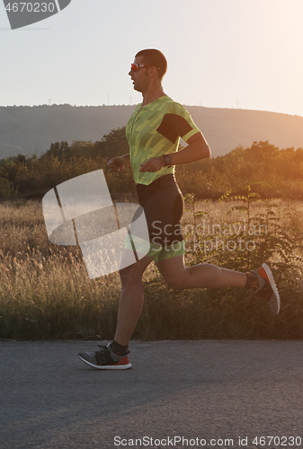 Image of triathlon athlete running on morning trainig