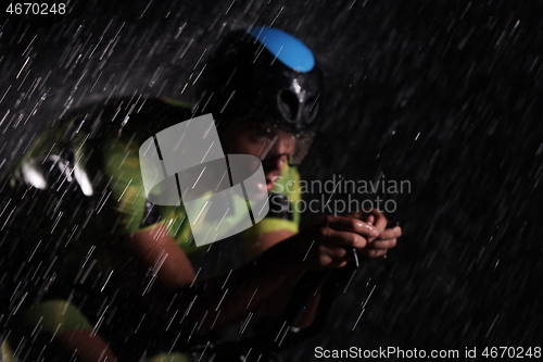 Image of triathlon athlete riding bike fast on rainy night