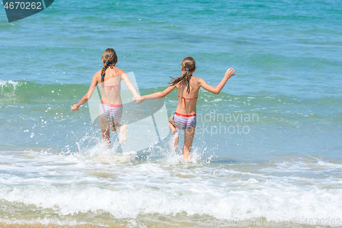 Image of Girlfriends ran into the sea, view from the back